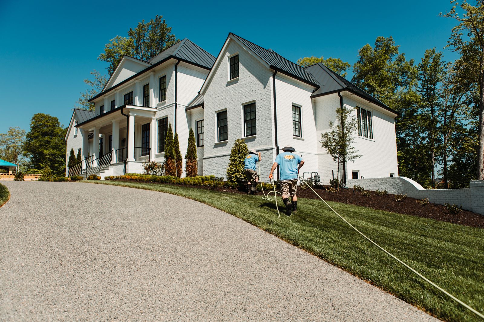 Pressure Washing Workers Driveway Cleaning White Brick